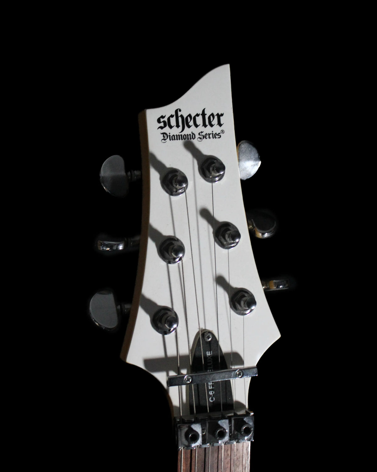 Schecter C6 FR Deluxe electric guitar by CDS Guitars, showcasing a sleek black finish, maple neck, and Floyd Rose tremolo system.