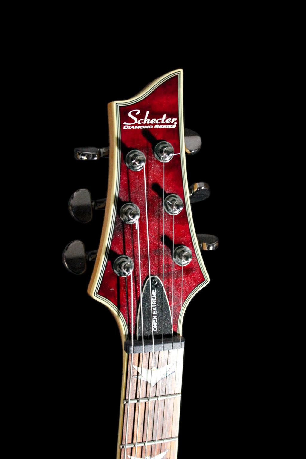 Schecter Omen Extreme electric guitar with sleek black body and chrome hardware, featuring a modern design and dual humbucker pickups.
