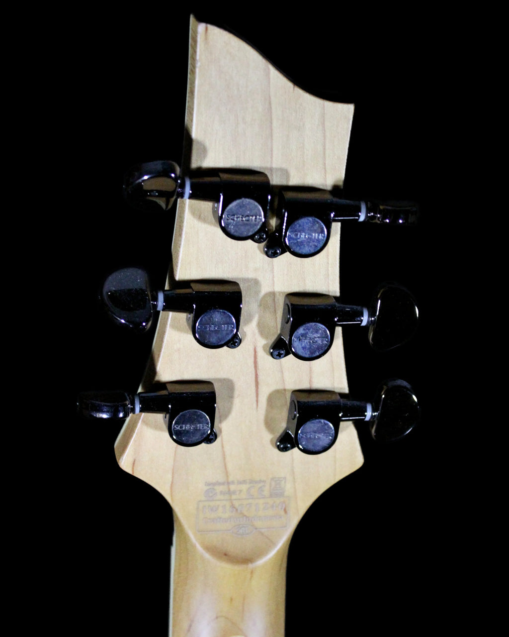 Schecter Omen Extreme guitar with black finish, shown on a stand, featuring dual humbucker pickups and sleek design.